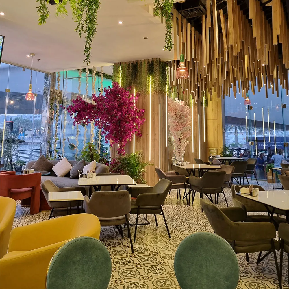 Interior of Nargileci Eleven Cafe with marina-view seating, hanging greenery and bougainvillea