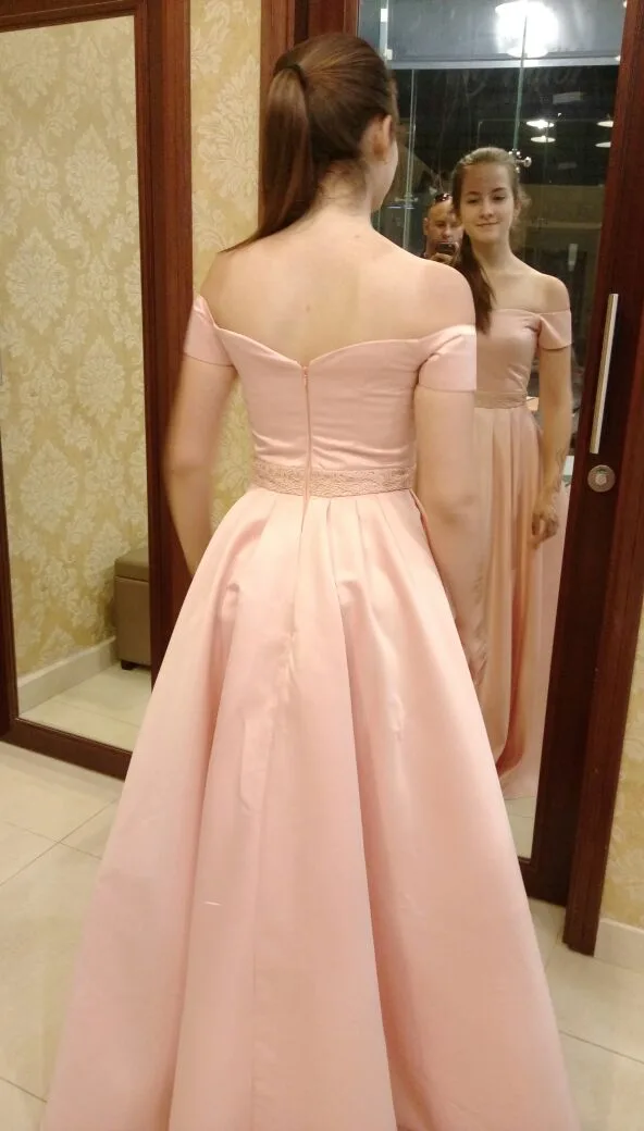 Client wearing a blush off-the-shoulder gown, viewed from behind in a mirror