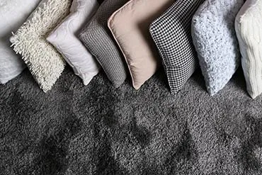 A row of soft cushions on a deep-pile rug