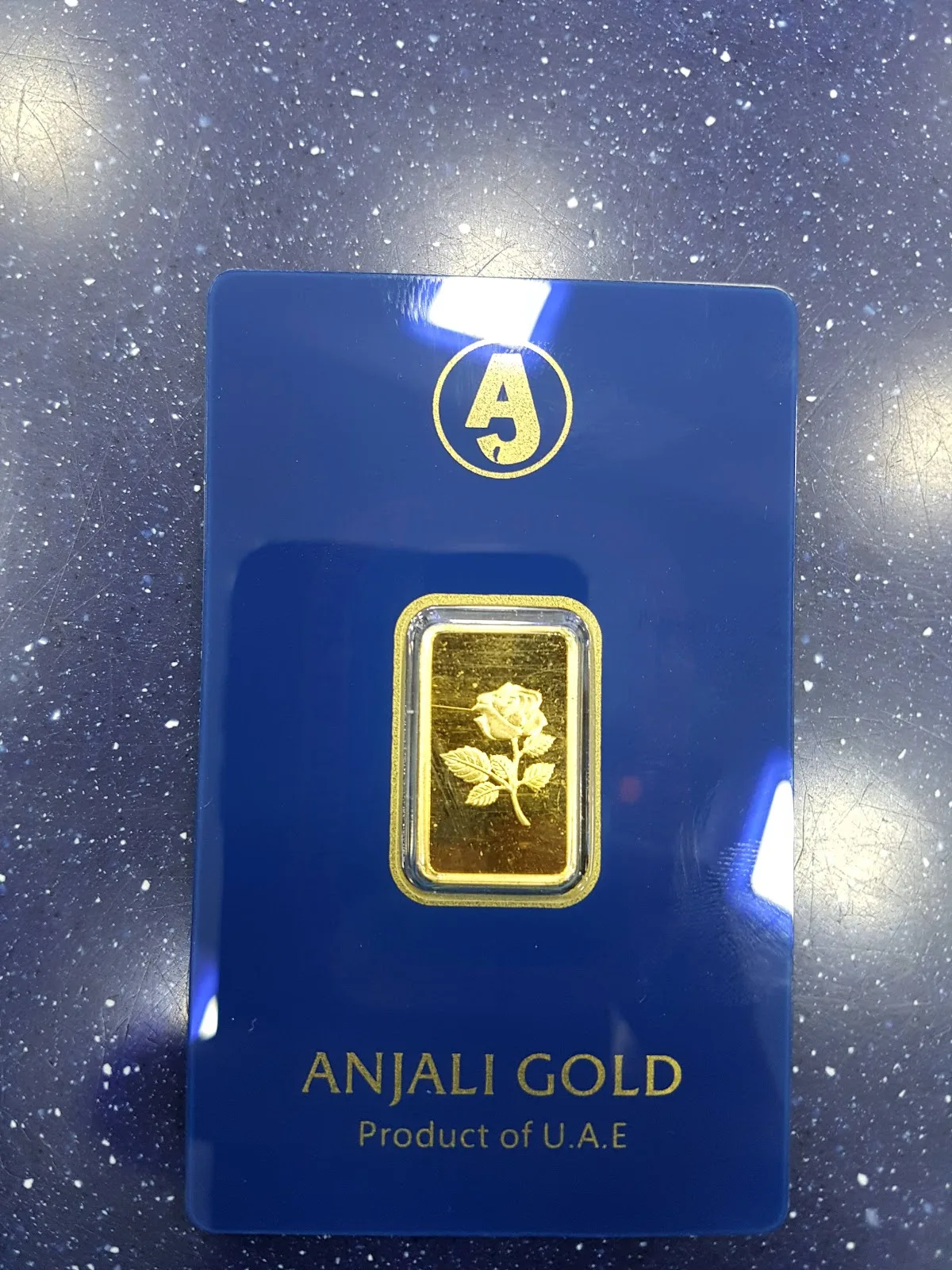 Anjali Gold rose-design fine gold bar sealed in a blue certificate card
