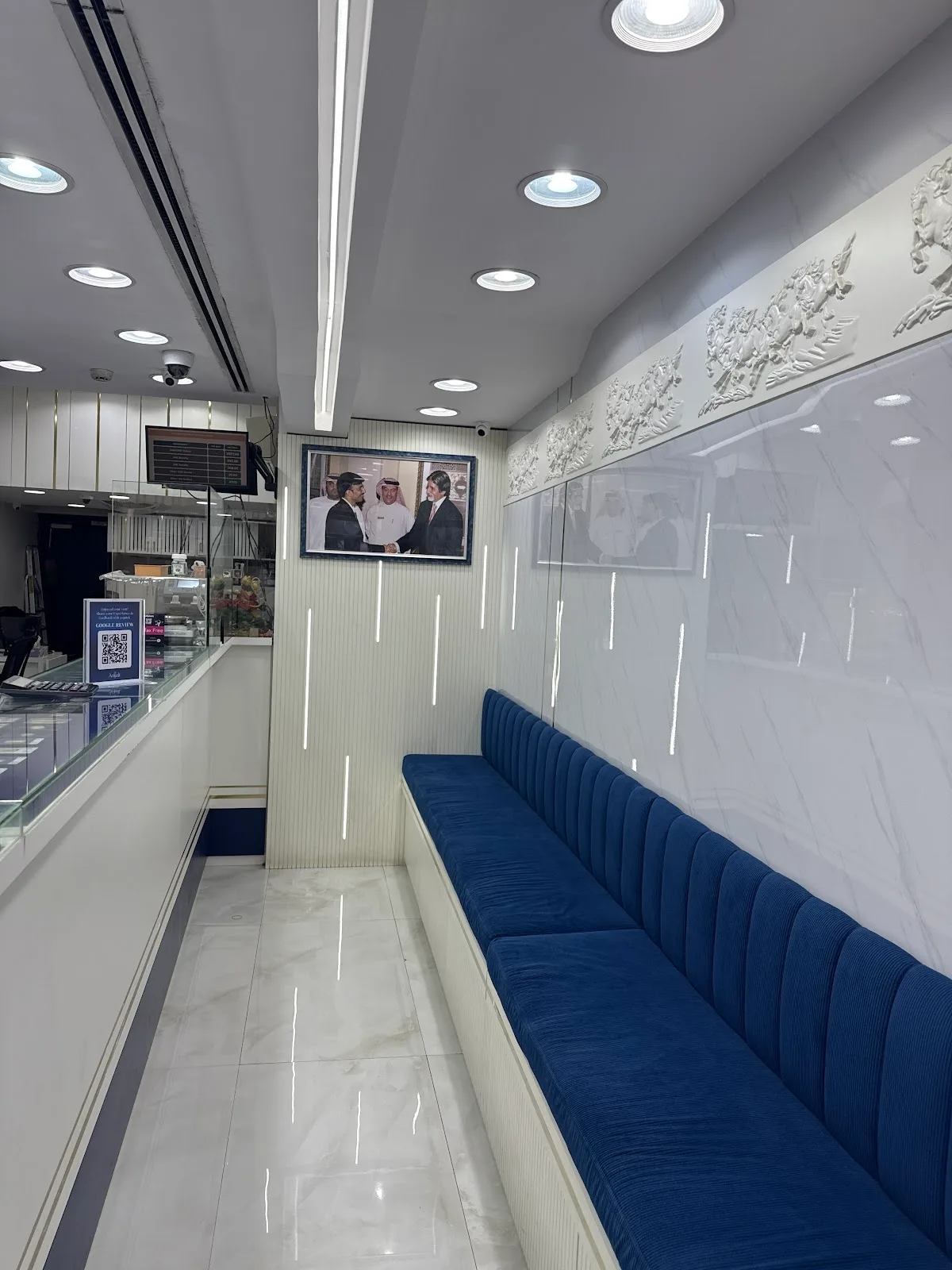 Showroom seating area with framed photographs and gold display counter
