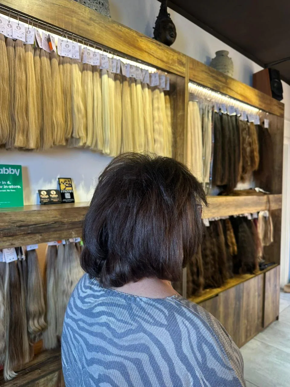 A client viewing the hair-extension shade wall at Paulista