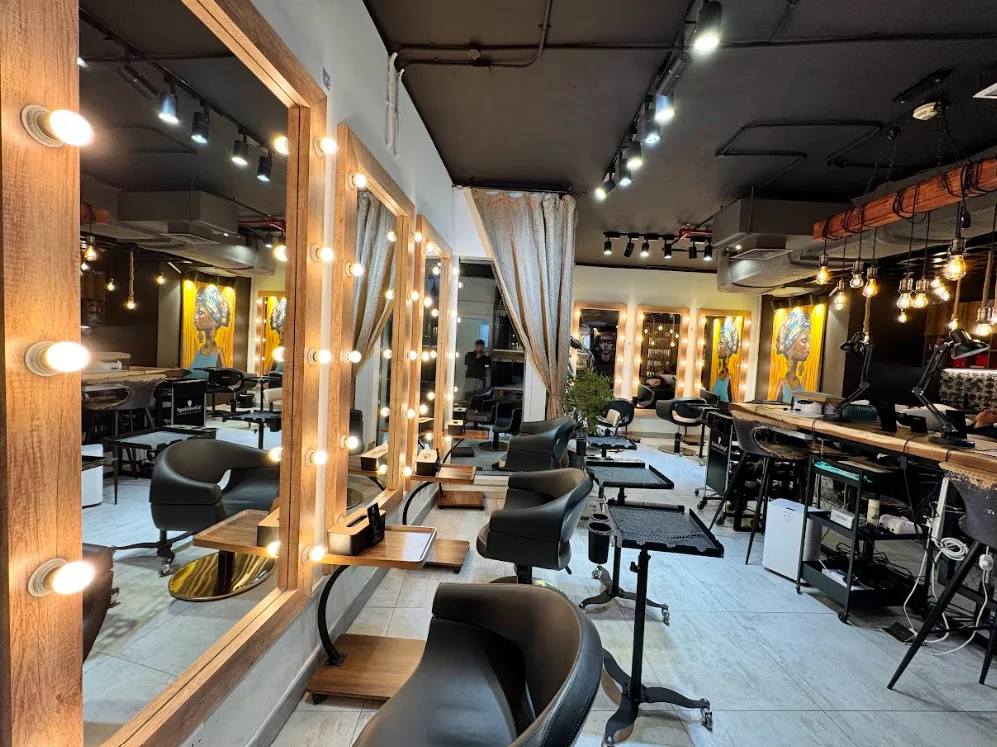 Inside Paulista Beauty Salon — warm wood styling stations with bulb-lit mirrors