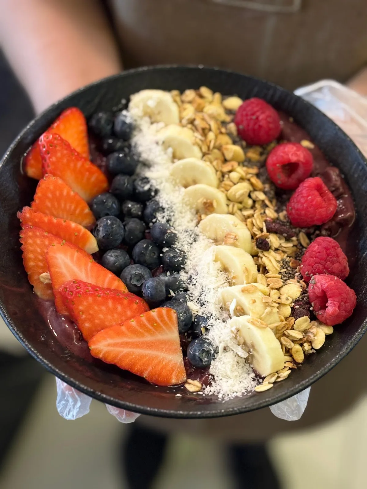 An açaí bowl topped with fresh fruit, banana and granola