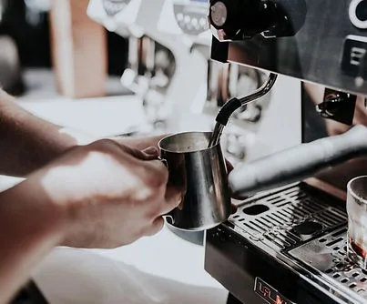 Barista steaming milk on an espresso machine