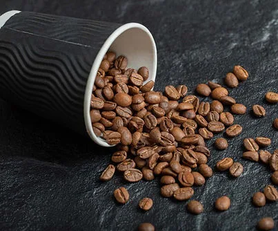 Roasted coffee beans spilling from a Roast cup