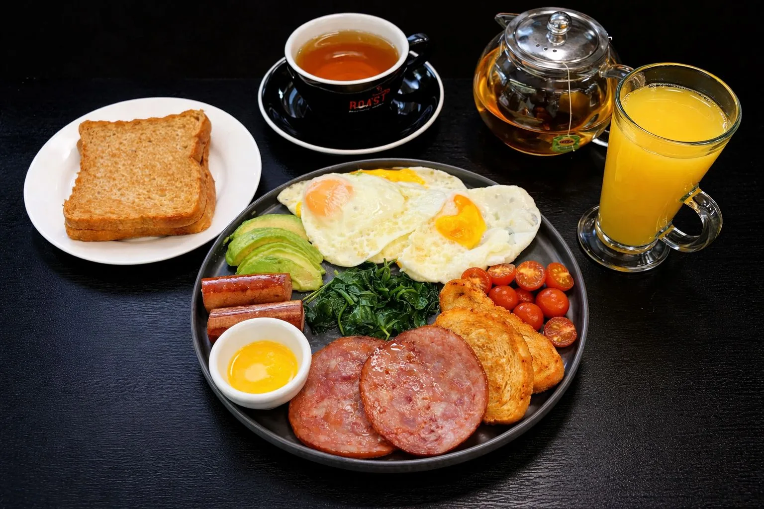 A full breakfast plate with eggs, avocado, tomatoes and toast