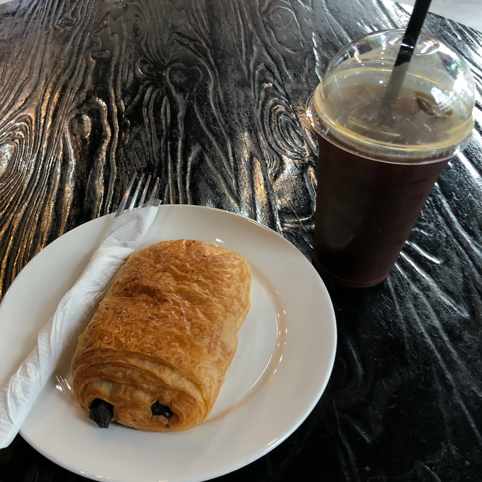 A pain au chocolat with an iced coffee