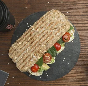 A pressed panini sandwich on a slate board