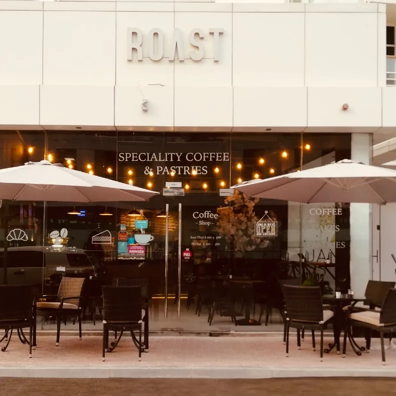 The Roast storefront with outdoor seating and parasols