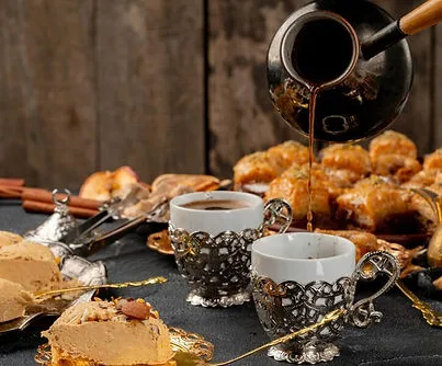 Turkish coffee poured beside baklava