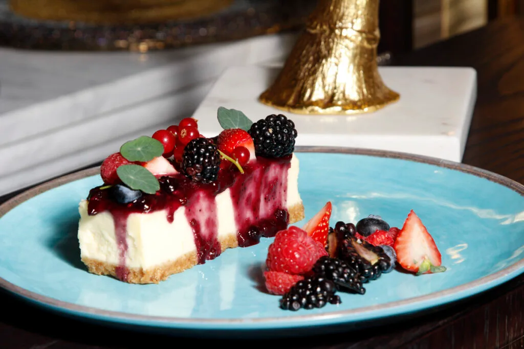 Berry-topped cheesecake on a blue plate