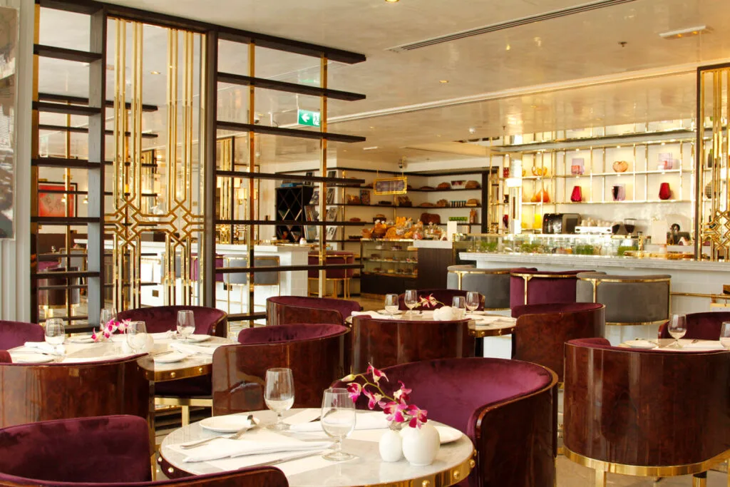 Café Society Dubai dining room with marble tables, velvet chairs and gold detailing