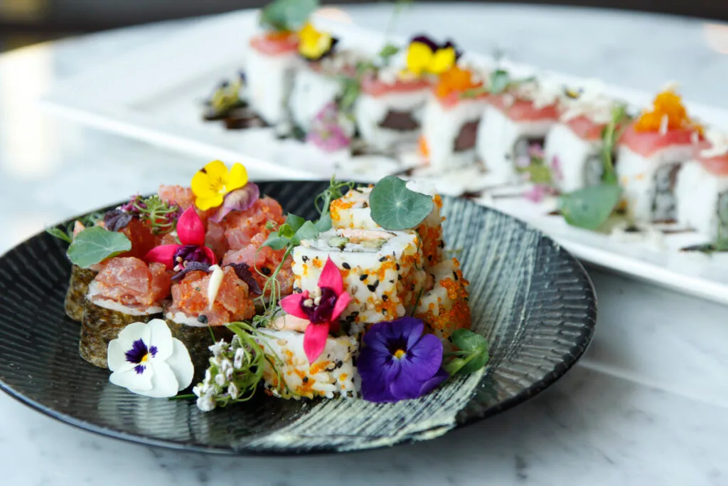 Plated sushi and maki garnished with edible flowers