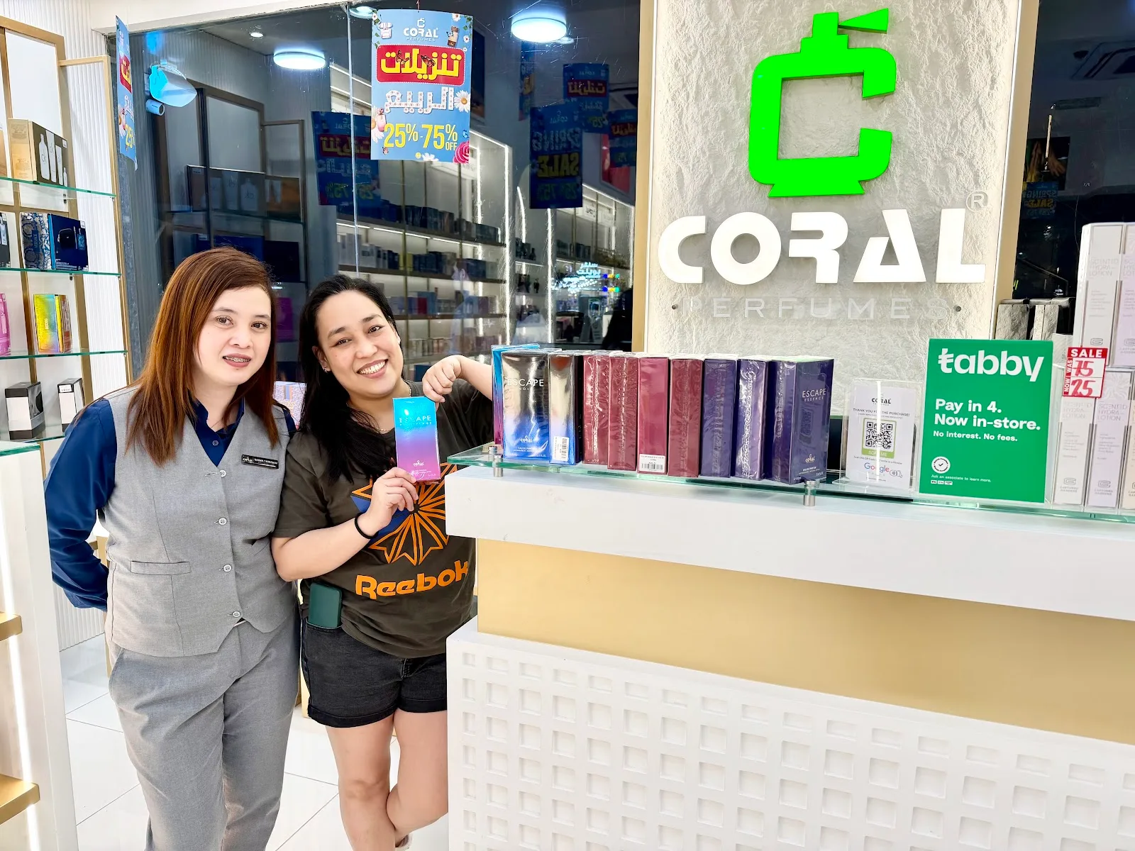 Happy customer at the Coral Perfumes counter with the Escape display