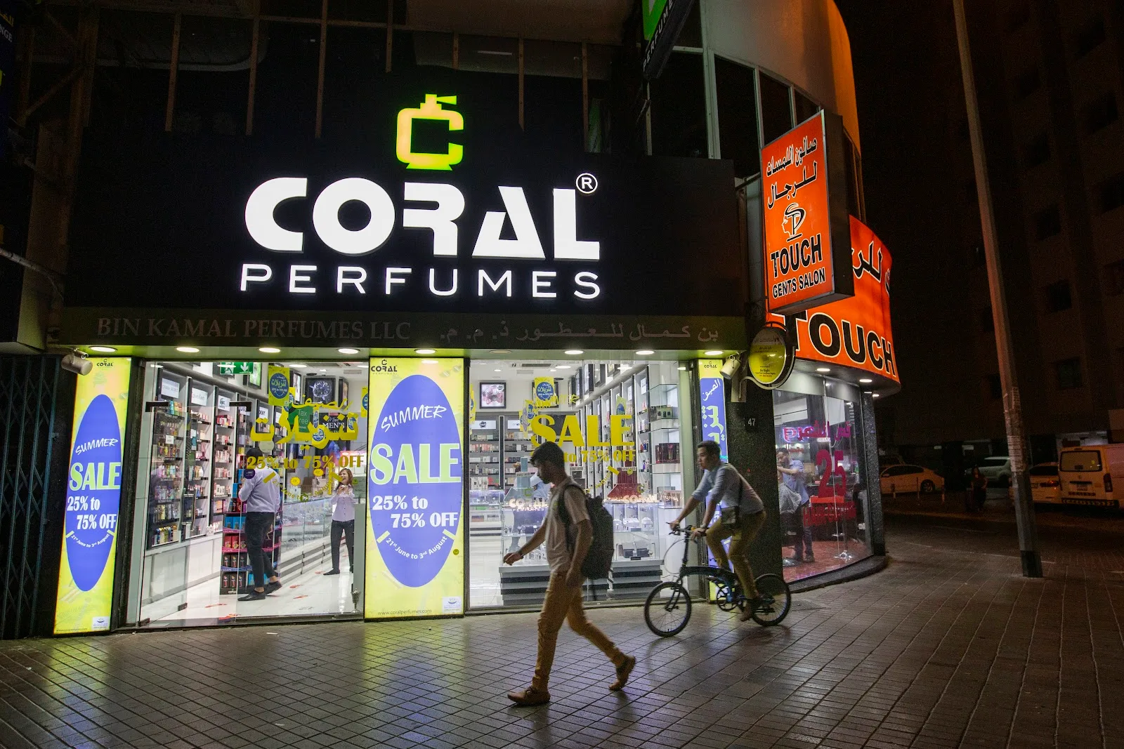 Coral Perfumes storefront lit up at night on Al Rigga Road, Deira, Dubai