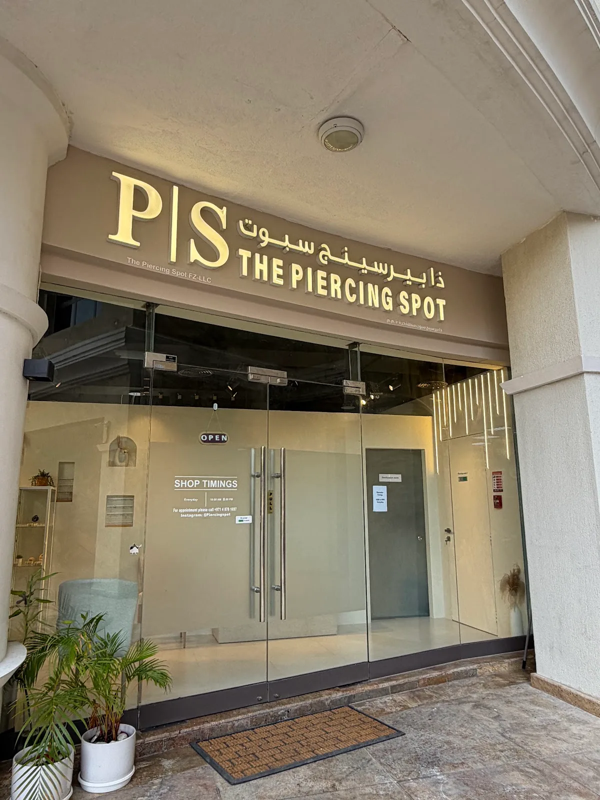 The Piercing Spot glass storefront with gold lettering and 'Open' sign