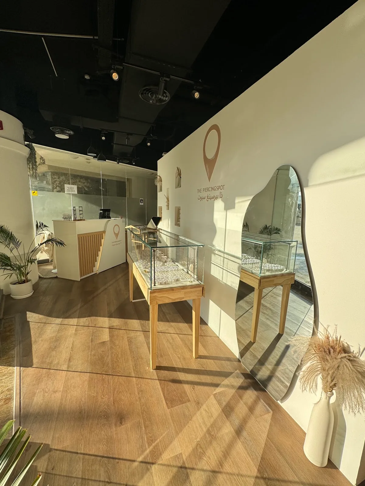 Studio interior with glass jewellery display cases and a wavy mirror