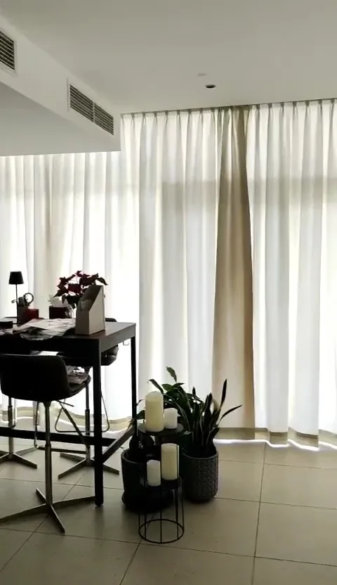 Floor-to-ceiling pleated curtains in a bright interior