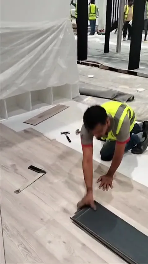 Technician installing timber-look flooring on a commercial fit-out