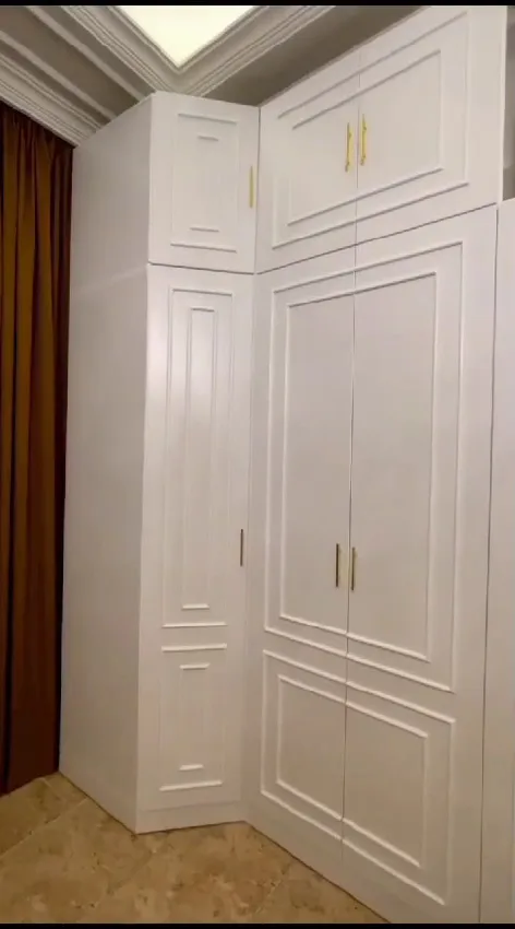 Panelled white corner wardrobe with gold handles