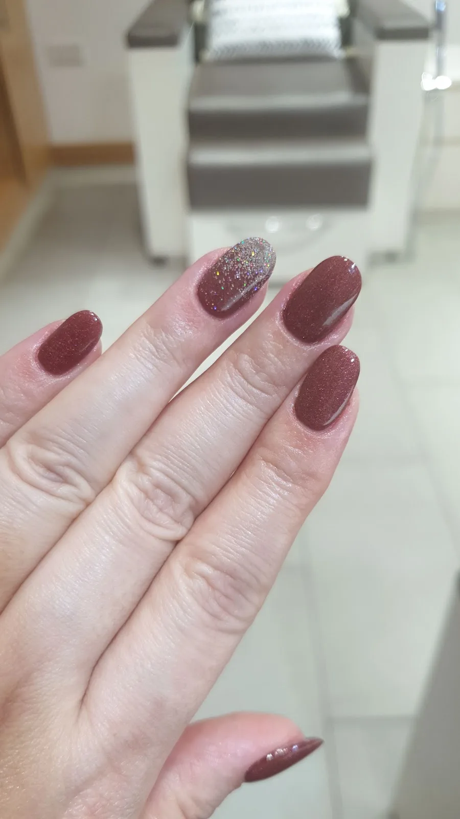Glossy mauve nails with glitter accent
