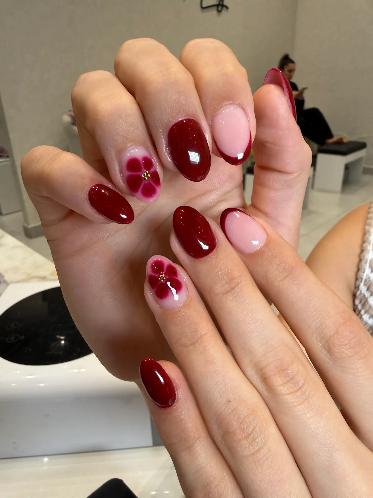 Deep red nails with floral accent
