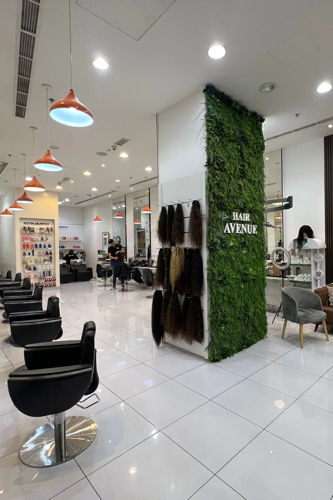 Interior of Hair Avenue salon with styling stations and a green wall