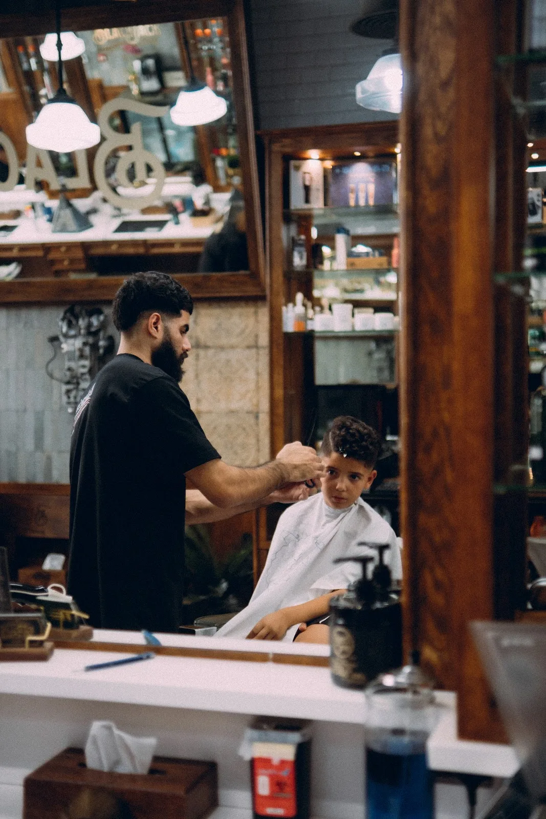A young boy getting a haircut in the vintage barbershop