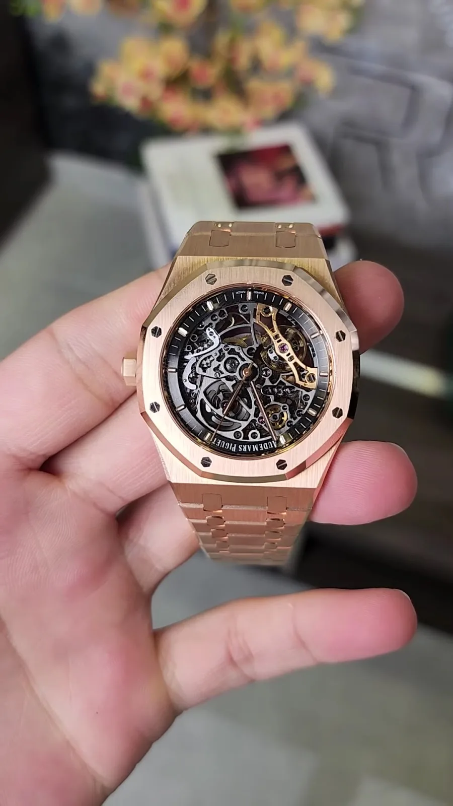Rose gold openworked sports watch held in hand