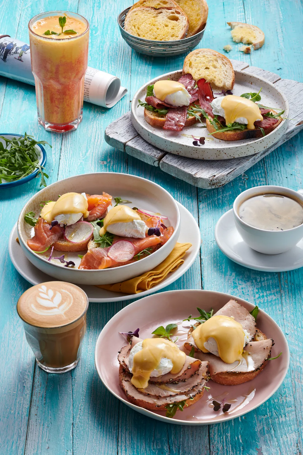 A spread of eggs benedict, toast, fresh juice and coffee on a table at The Coffee Club JLT