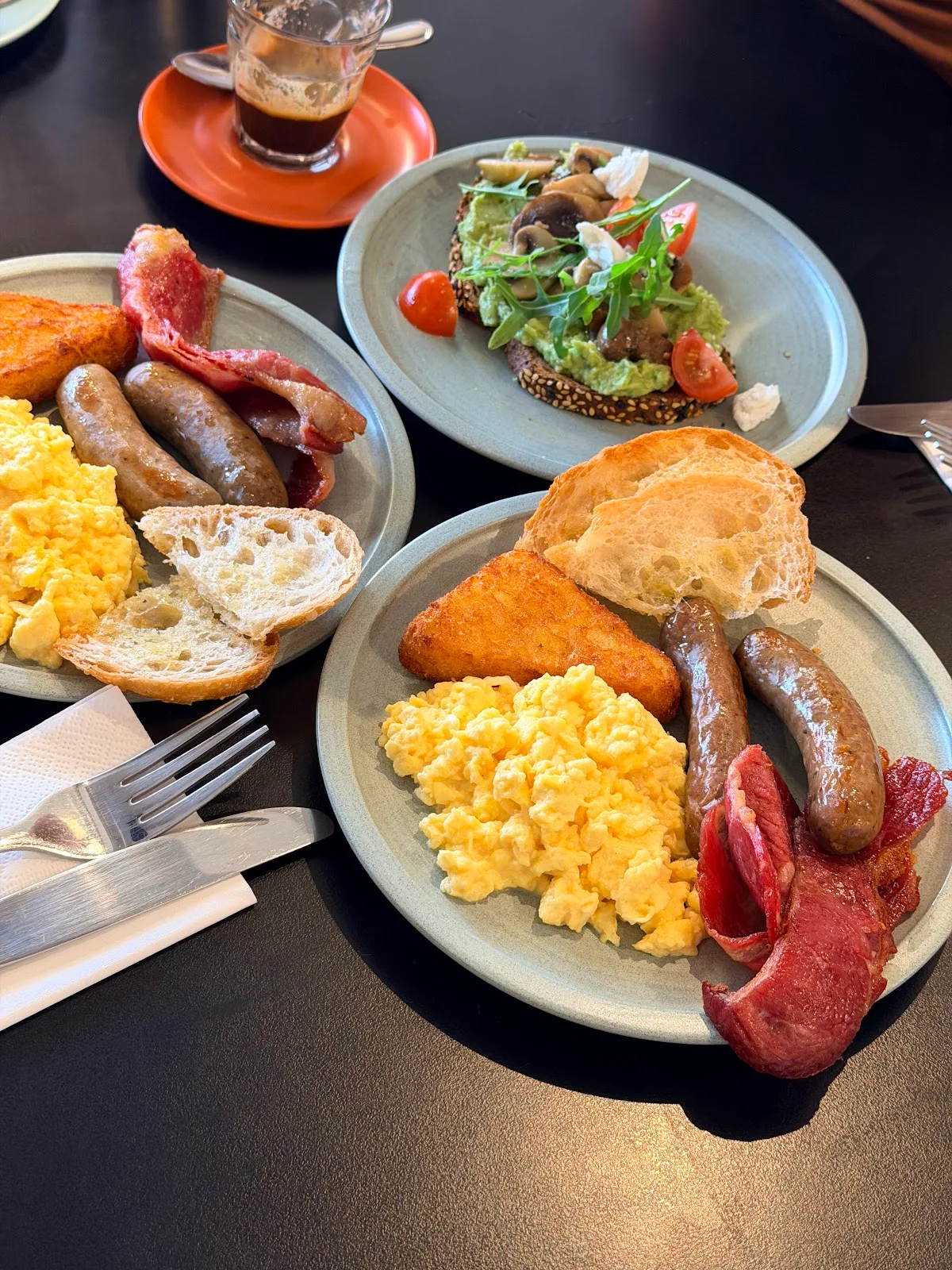 A full breakfast plate with eggs, sausages, hash brown and toast