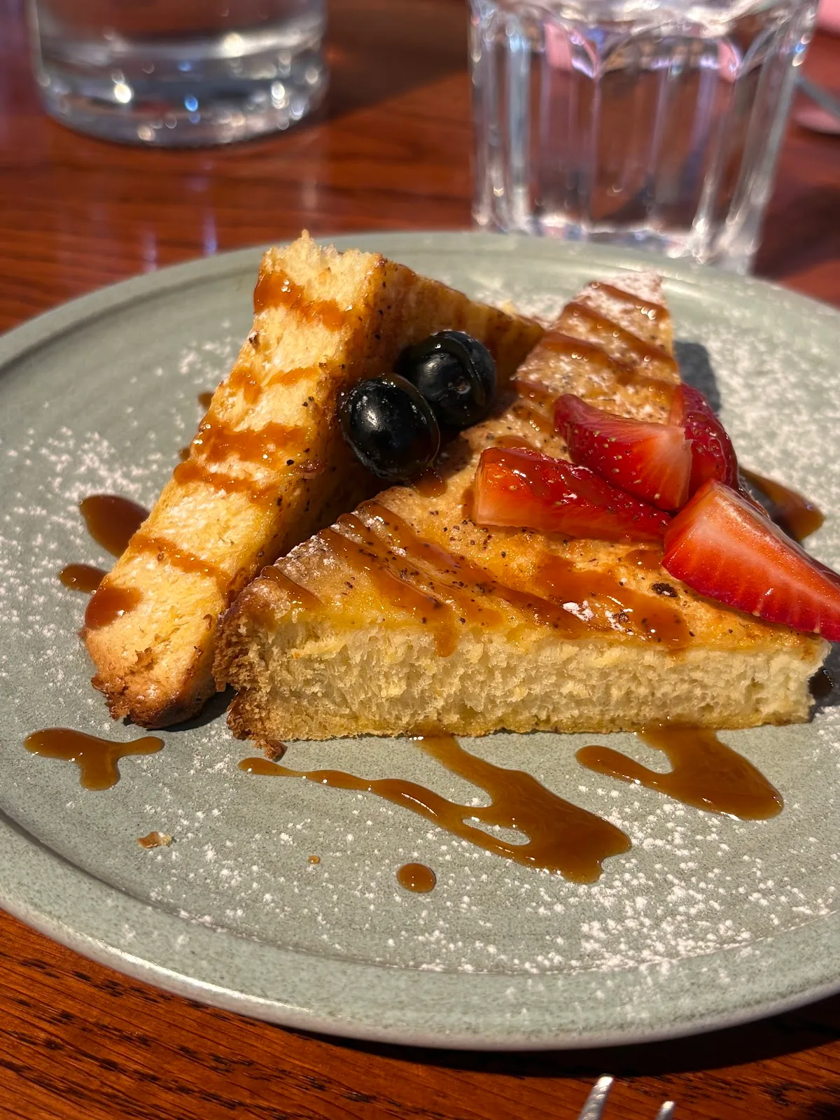 French toast topped with strawberries, blueberries and caramel