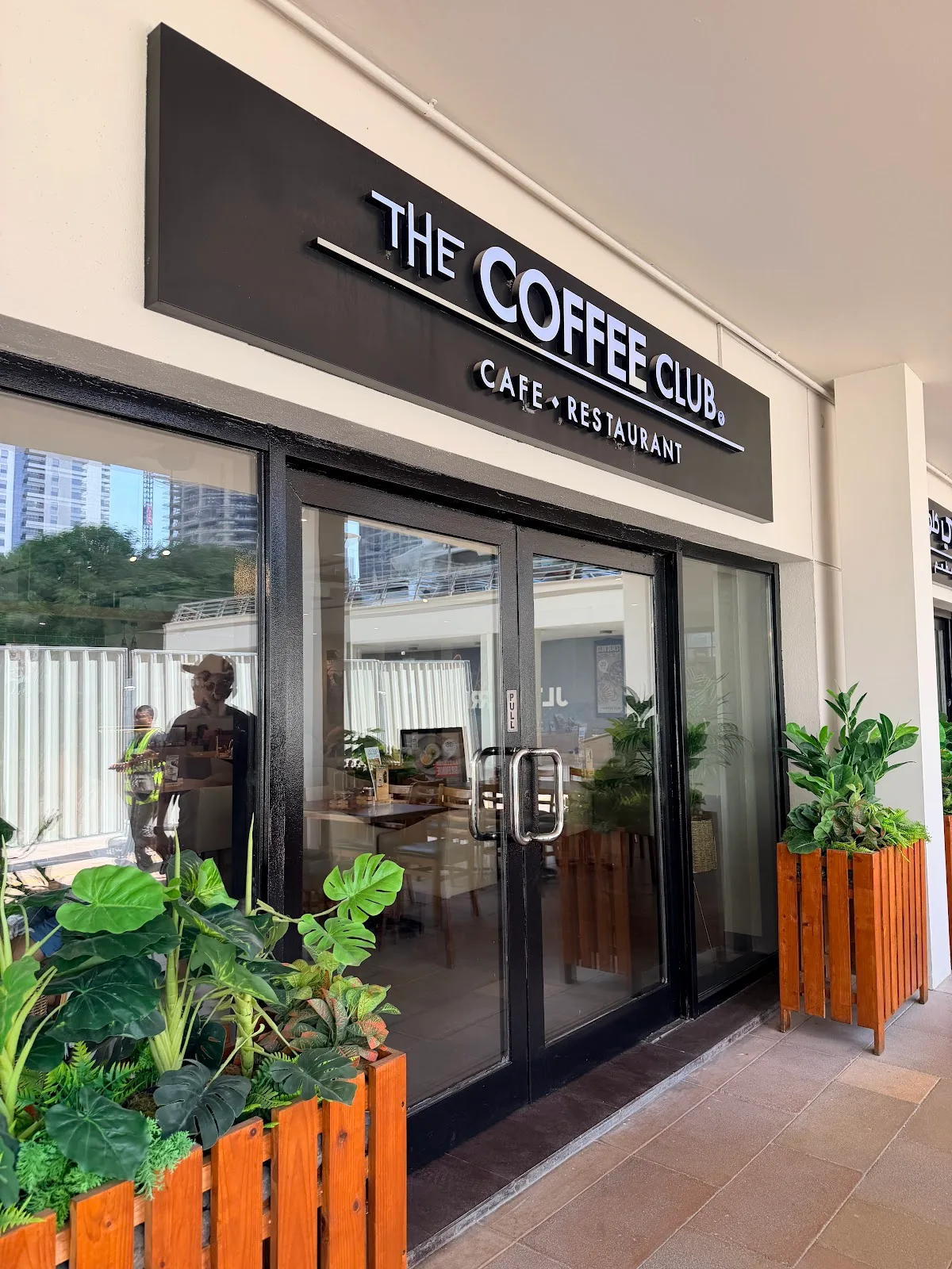 The Coffee Club cafe and restaurant storefront sign with planters