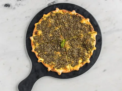 Fresh-baked Persian flatbread topped with herbs and sesame