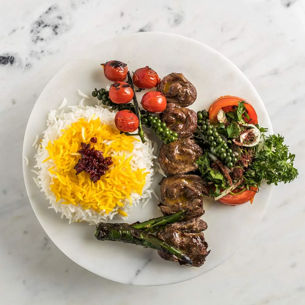 Grilled lamb chops with saffron rice and herbs on a marble plate