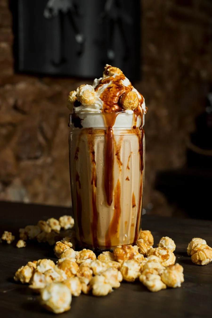 Caramel milkshake topped with cream and caramel popcorn