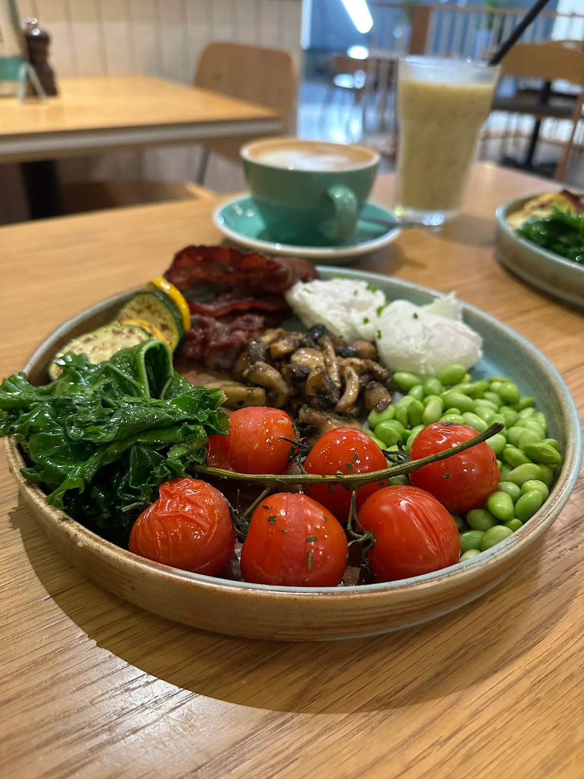 Breakfast plate of greens, tomatoes, eggs and edamame with coffee