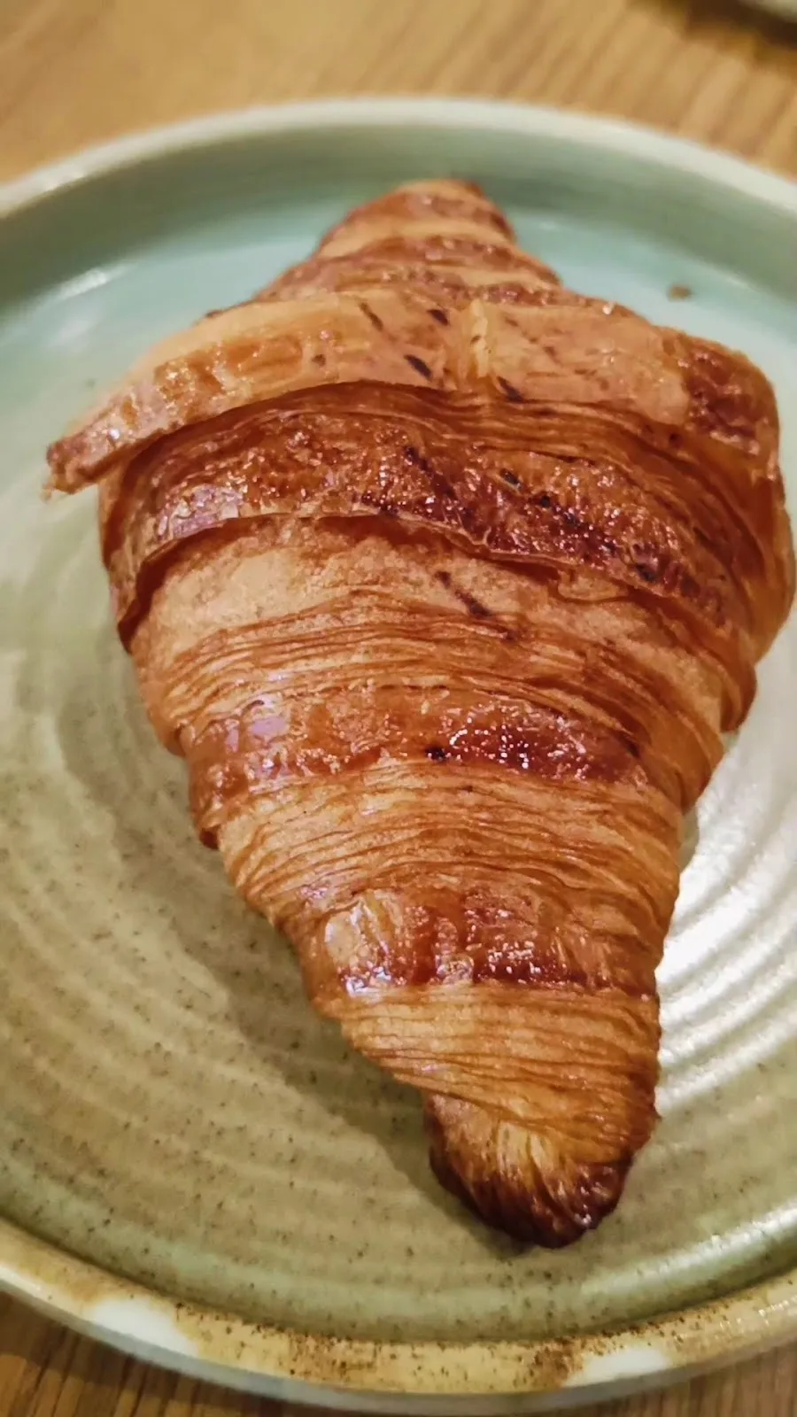 Freshly baked croissant on a ceramic plate