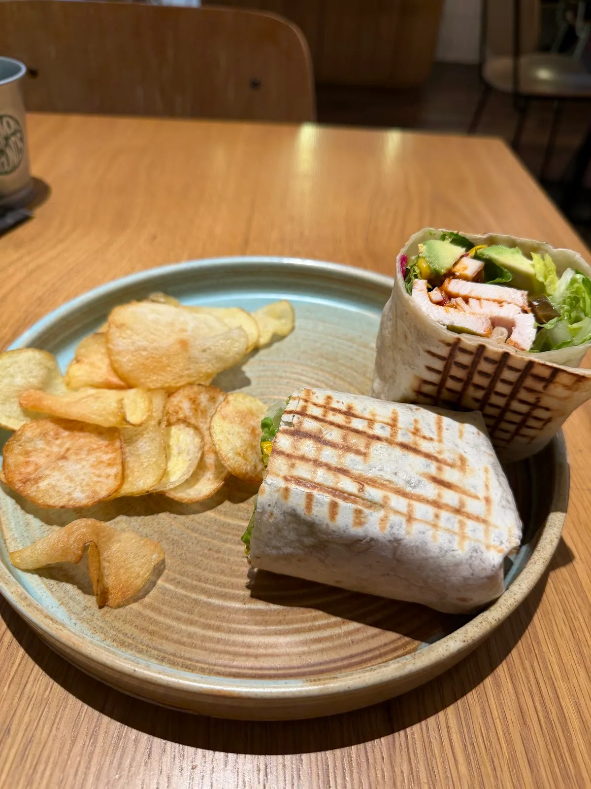 Toasted chicken and avocado wrap with a side of crisps