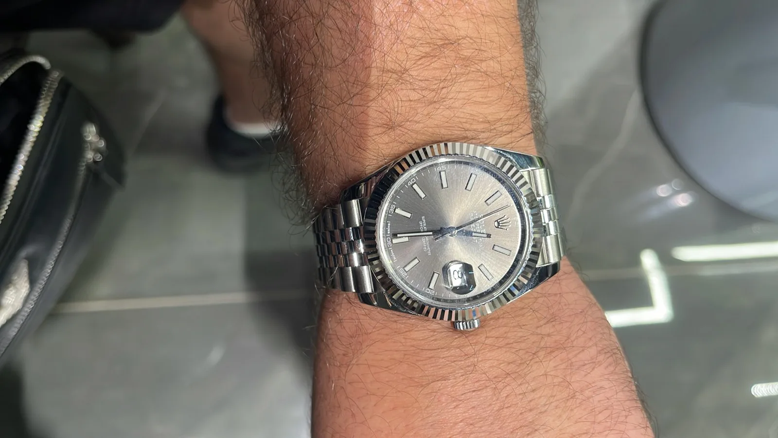 A Rolex Datejust being tried on the wrist