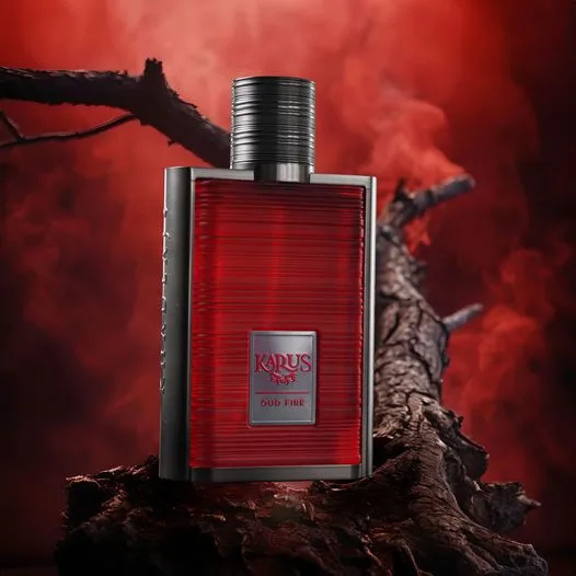 A deep red Khadlaj fragrance bottle styled on driftwood