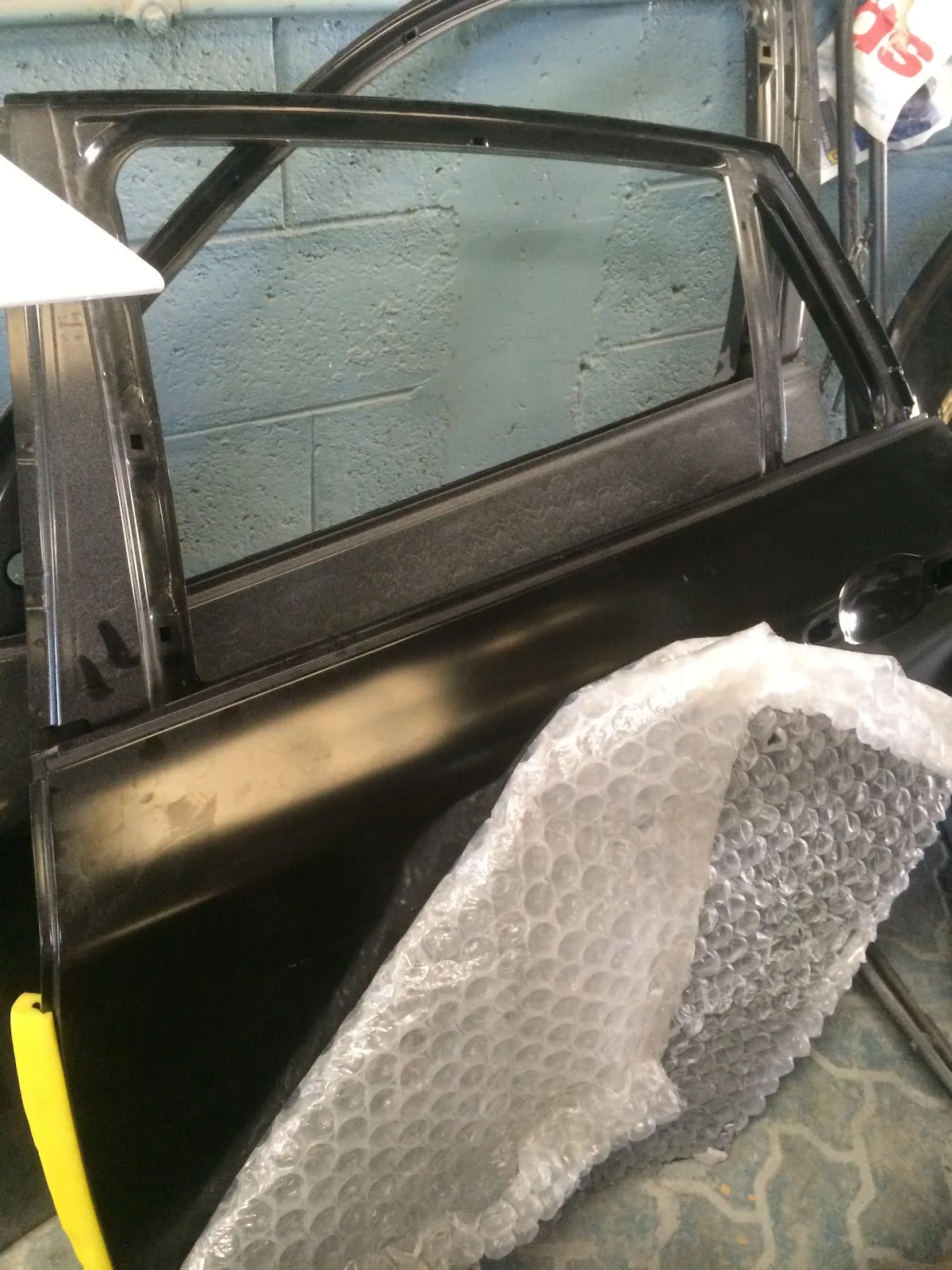A car door panel prepared for bodywork at DX Garage