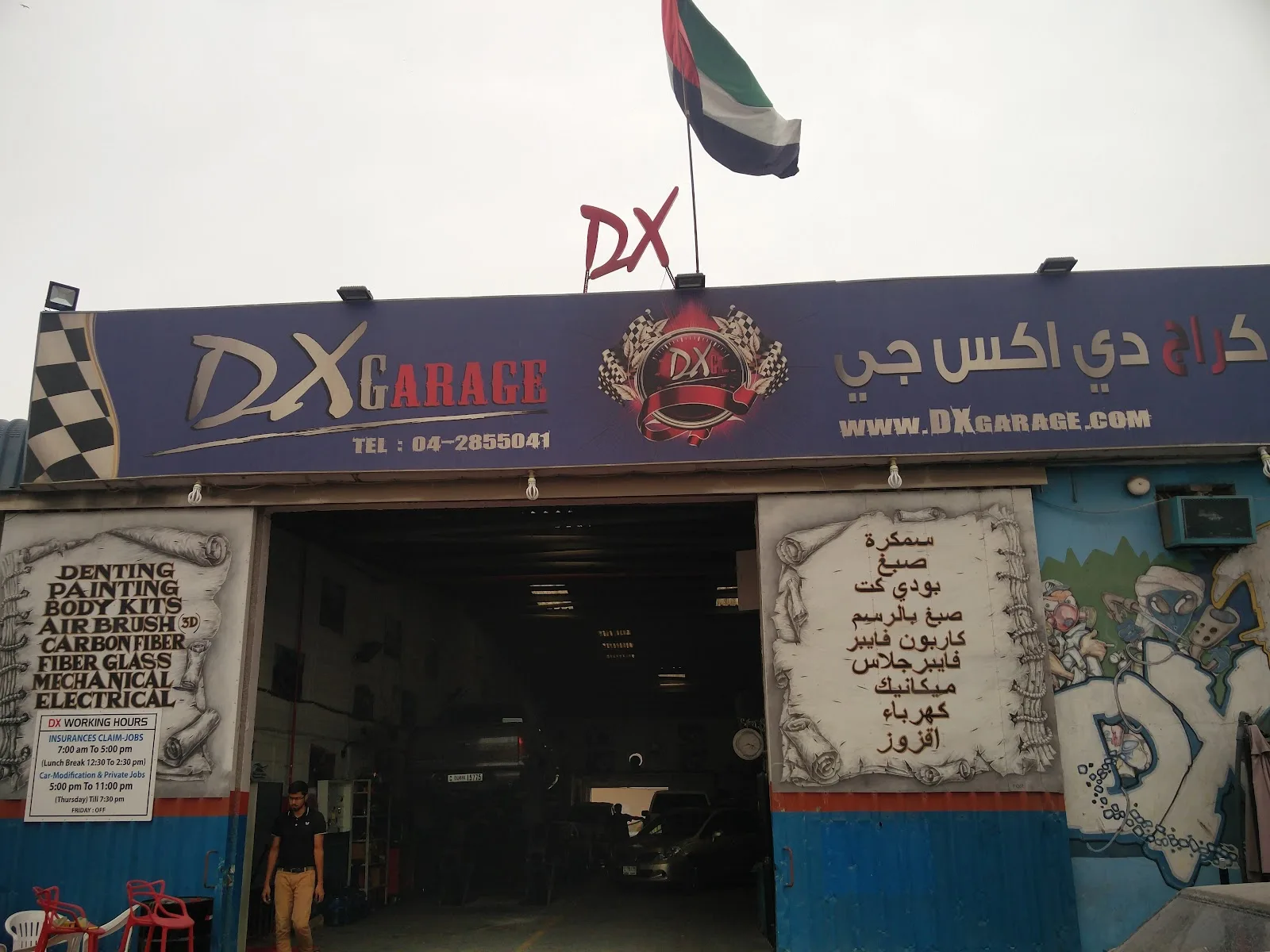 DX Garage storefront in daytime with UAE flag and service list