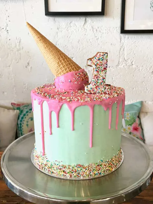 Mint and pink drip celebration cake with a number-one topper and sprinkles
