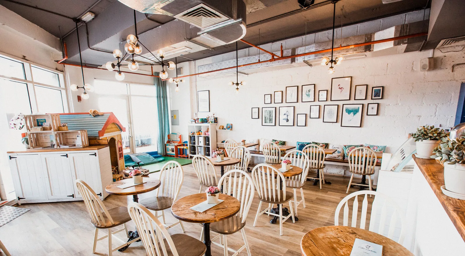 Bright café interior with white-brick walls, pendant lights and wooden tables