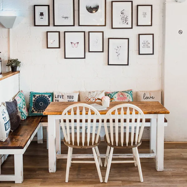 Cosy banquette dining nook with cushions and a framed gallery wall