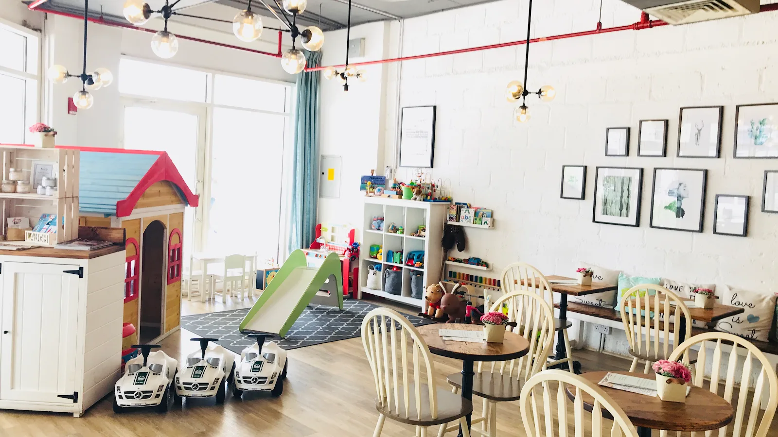 Bright children's play corner with a wooden playhouse, slide and toys