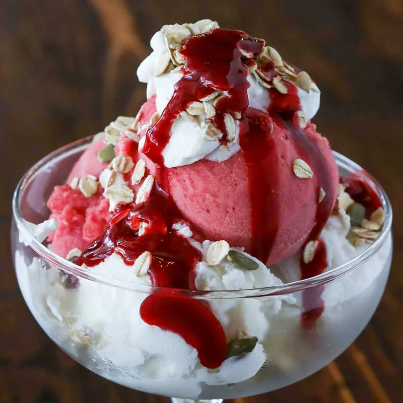 Strawberry sorbet sundae topped with cream and granola
