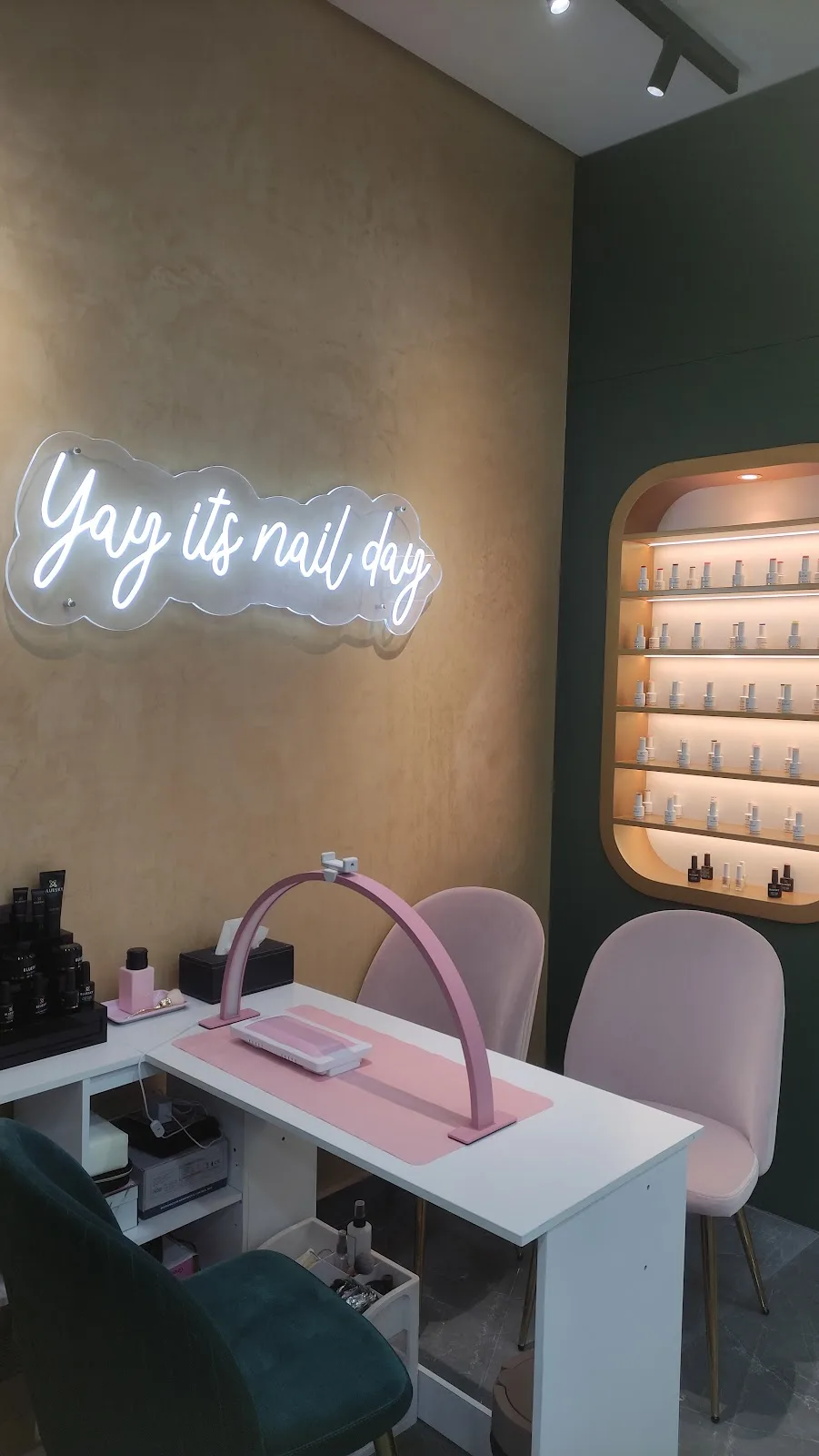 Pink nail station under a neon Yay its nail day sign